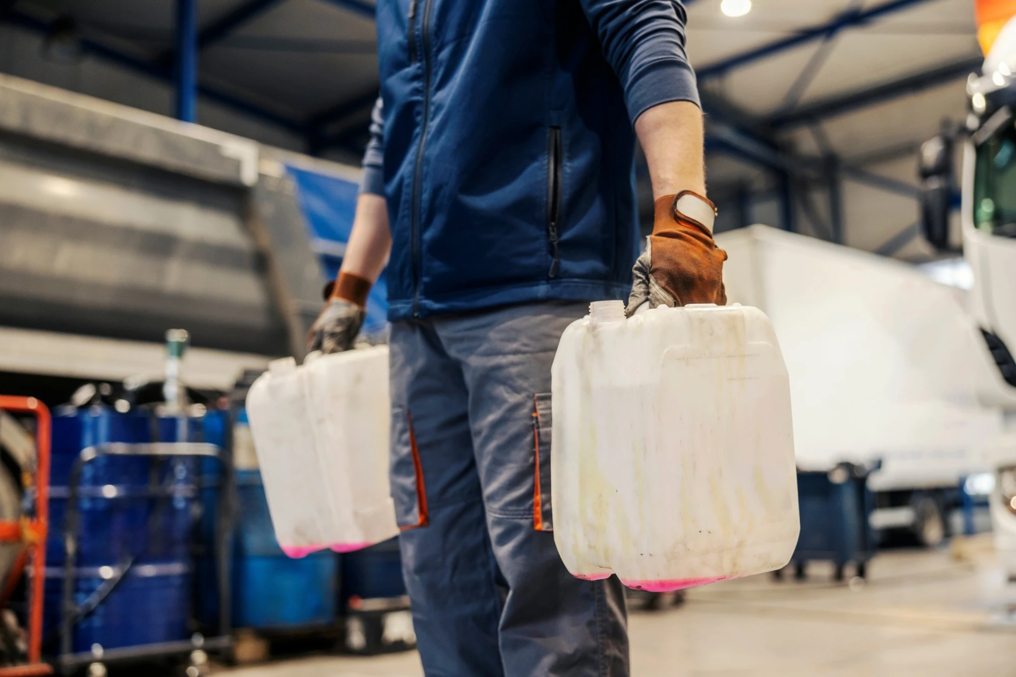 Operario transportando jerrycans HDPE en la planta